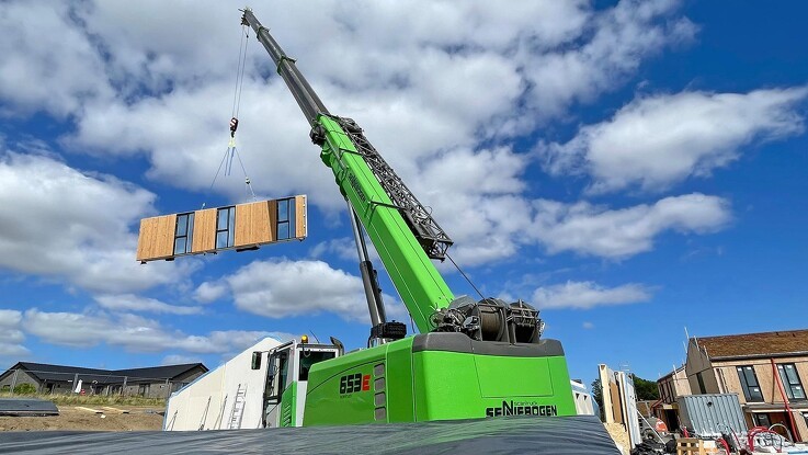 50 tons teleskopkran rejser træhuse på stribe
